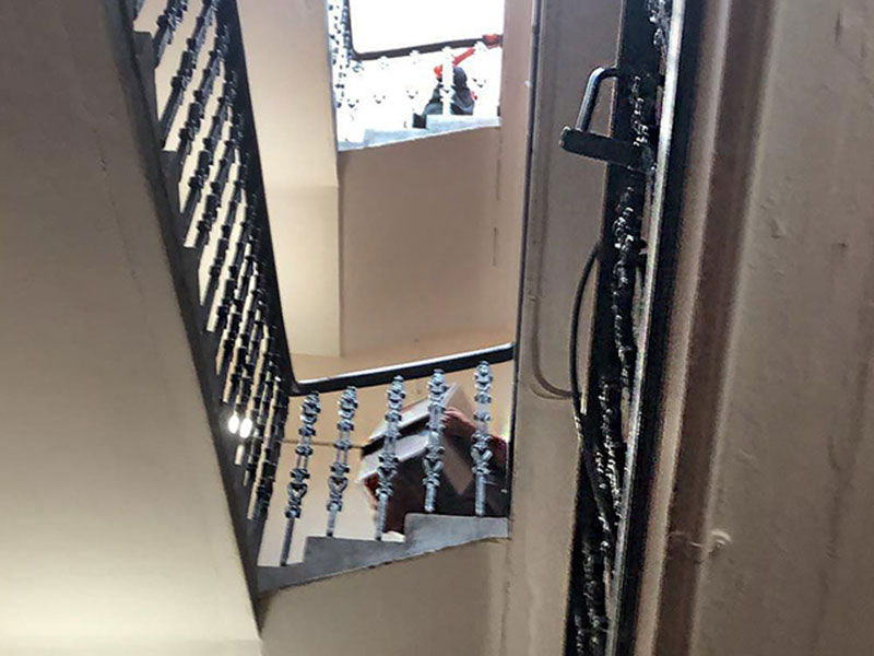 removals team carrying boxes down stairs in an Edinburgh tenement block